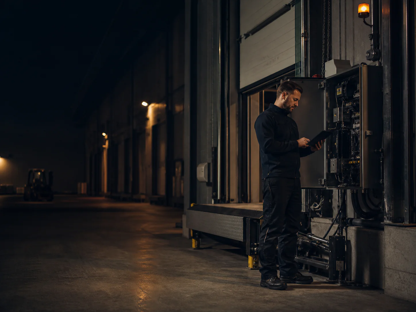 Servicetechniker prüft Tor- und Fördertechnik in einer modernen Industriehalle